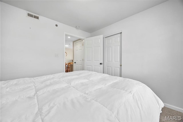 carpeted bedroom with baseboards and a closet