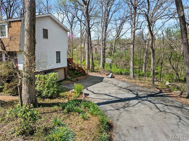 1536 S Mason Rd, Saint Louis, MO 63131 - view of side of home featuring driveway, an attached garage, and stairway