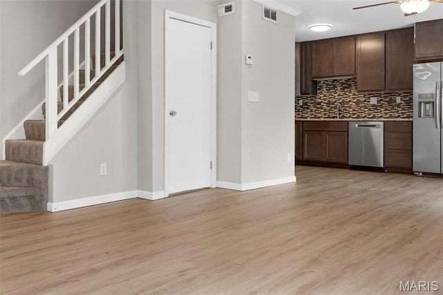 11148 Whispering Oaks Dr, Saint Louis, MO 63136 - kitchen with appliances with stainless steel finishes, tasteful backsplash, light wood-style floors, baseboards, and dark brown cabinetry