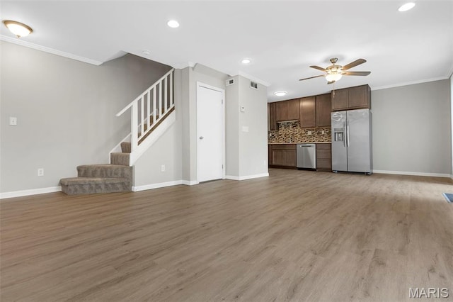 11148 Whispering Oaks Dr, Saint Louis, MO 63136 - unfurnished living room with a ceiling fan, stairway, crown molding, baseboards, and light wood-style floors