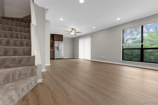 11148 Whispering Oaks Dr, Saint Louis, MO 63136 - unfurnished living room featuring stairway, crown molding, baseboards, wood finished floors, and ceiling fan