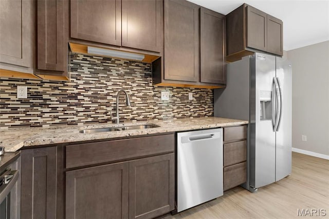 11148 Whispering Oaks Dr, Saint Louis, MO 63136 - kitchen with stainless steel appliances, a sink, light wood-style floors, decorative backsplash, and baseboards