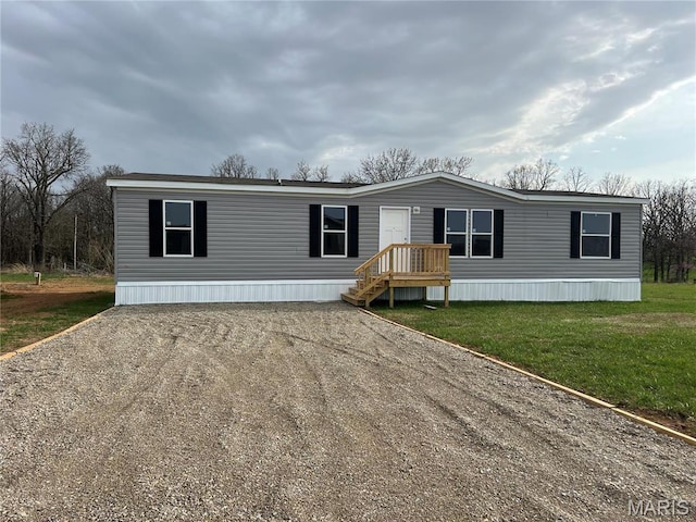 manufactured / mobile home with driveway and a front lawn