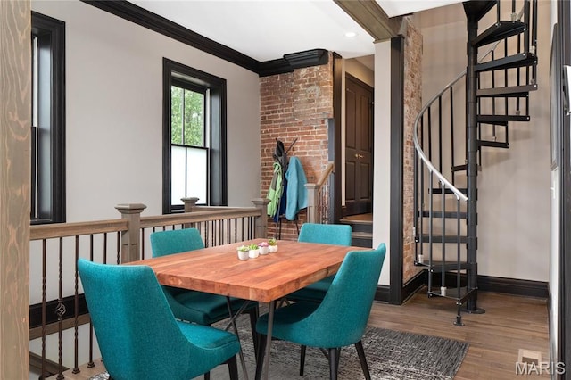 dining space with wood finished floors, stairway, ornamental molding, and baseboards