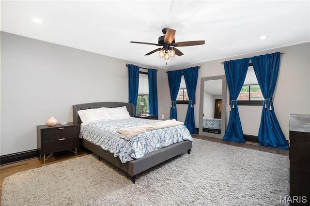 bedroom with wood finished floors, recessed lighting, baseboards, and ceiling fan
