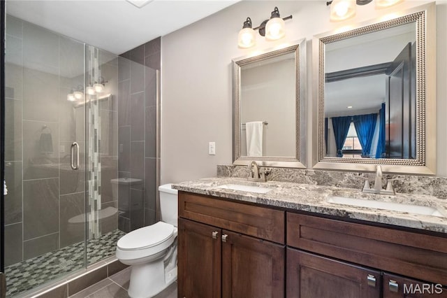 full bathroom with toilet, a shower stall, and double vanity