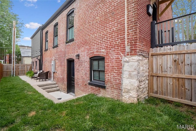 view of side of property with brick siding and a patio area