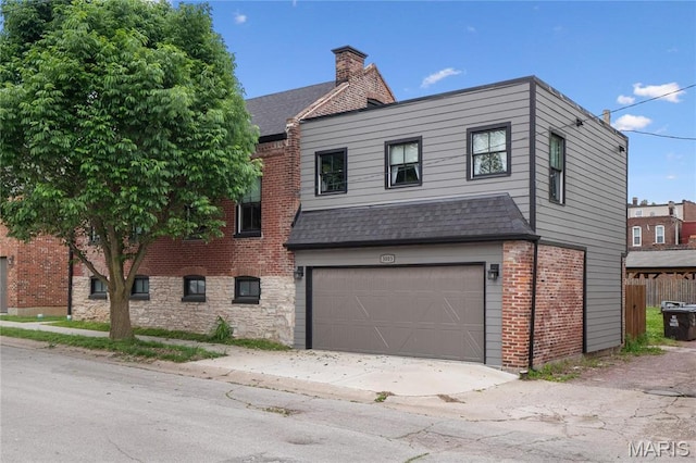view of front of home featuring a garage, brick siding, a shingled roof, and concrete driveway