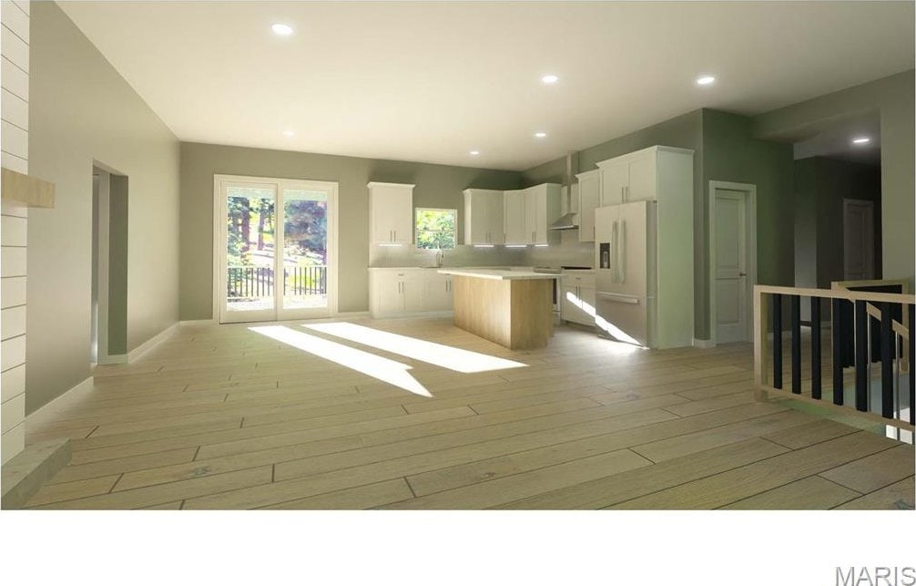 kitchen with white fridge with ice dispenser, a center island, light wood finished floors, open floor plan, and white cabinets