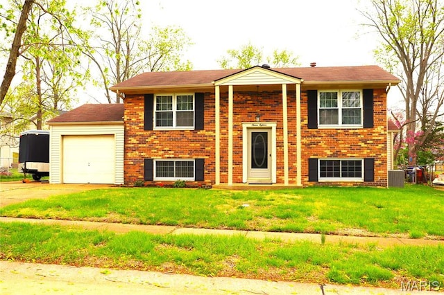 split foyer home featuring an attached garage, brick siding, driveway, and a front lawn
