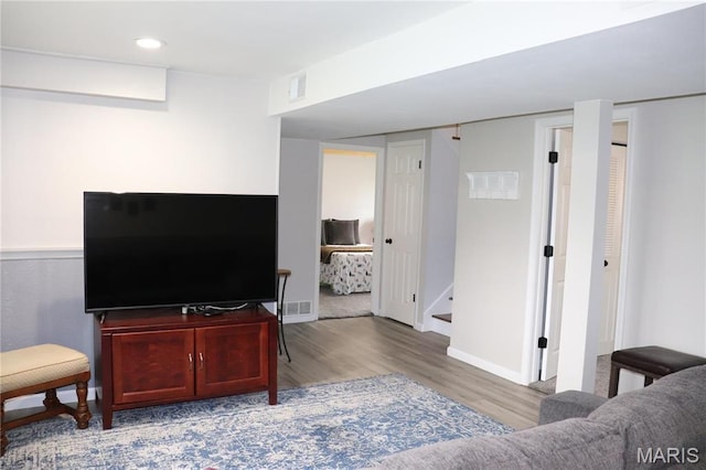 living area with wood finished floors, recessed lighting, baseboards, and stairs