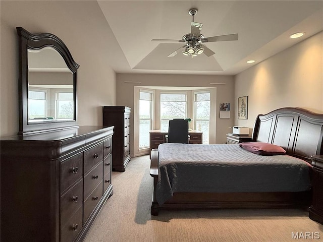 bedroom with multiple windows, light carpet, a raised ceiling, a ceiling fan, and recessed lighting