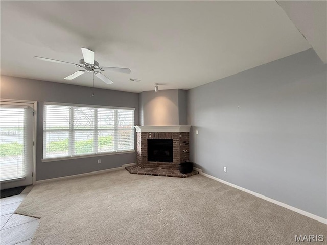 unfurnished living room featuring baseboards, carpet floors, ceiling fan, and a fireplace
