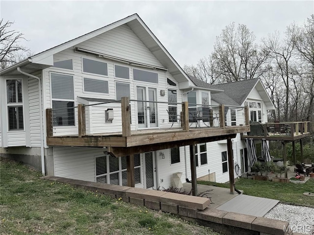 rear view of house featuring a deck, a yard, and a patio