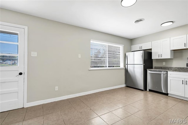 9738 Traverse Ln, Saint Louis, MO 63134 - kitchen with stainless steel appliances, plenty of natural light, white cabinets, and baseboards