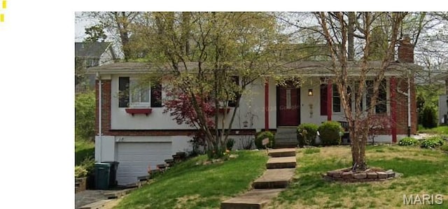 view of front of home featuring a garage, a front yard, and brick siding