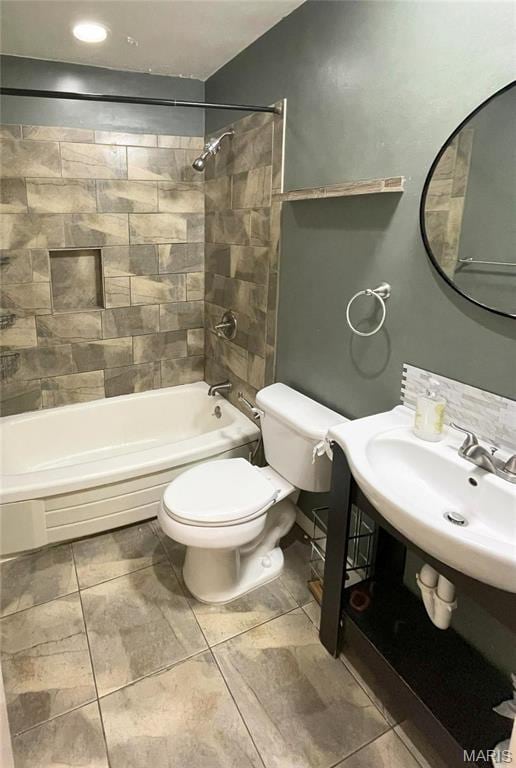 bathroom with toilet, shower / washtub combination, tile patterned flooring, and a sink