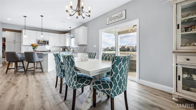 dining space with a chandelier, light wood finished floors, recessed lighting, and baseboards