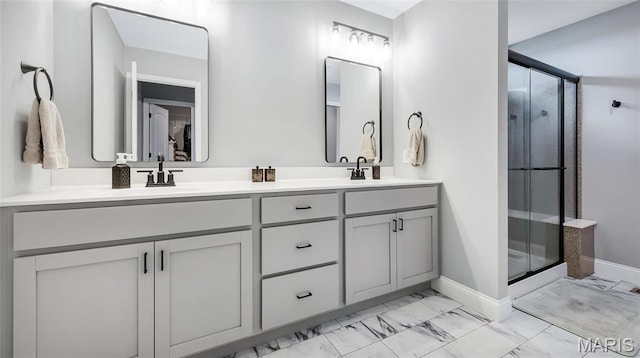 bathroom with marble look tile flooring, baseboards, a shower stall, and double vanity
