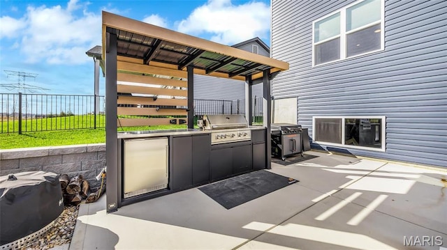 view of patio / terrace featuring an outdoor kitchen, grilling area, and fence