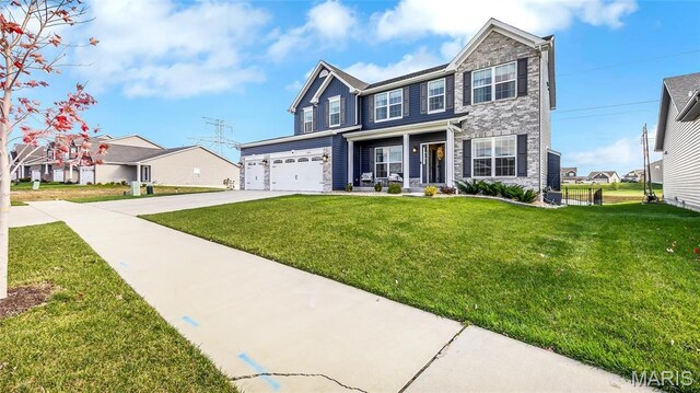 view of front of house with concrete driveway, a front lawn, covered porch, stone siding, and an attached garage