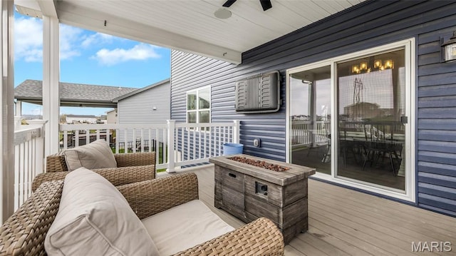 wooden deck with a fire pit and ceiling fan