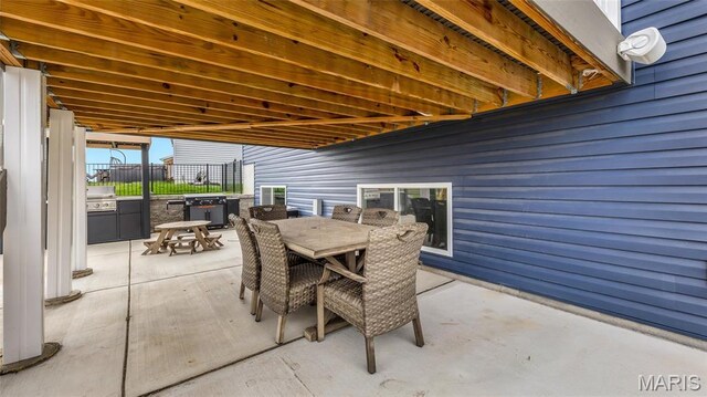 view of patio with outdoor dining space and fence