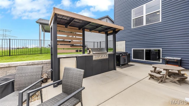view of patio / terrace with an outdoor kitchen, grilling area, and fence
