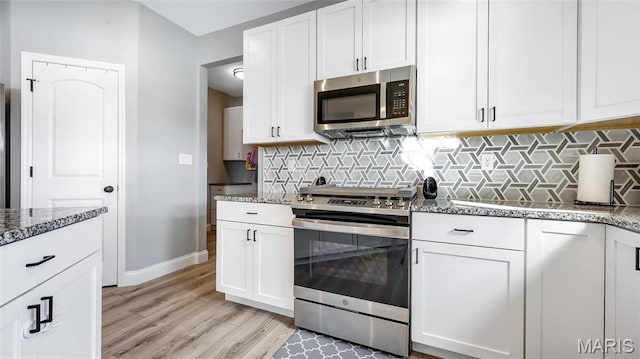 326 Summer Glen Ln, Saint Charles, MO 63301 - kitchen featuring stainless steel appliances, dark stone countertops, baseboards, light wood-type flooring, and white cabinetry