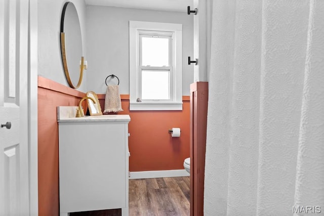full bathroom with vanity, wood finished floors, toilet, and baseboards