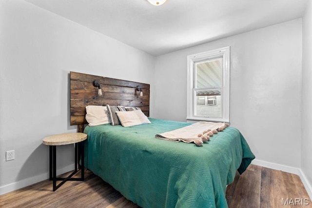 bedroom featuring wood finished floors and baseboards