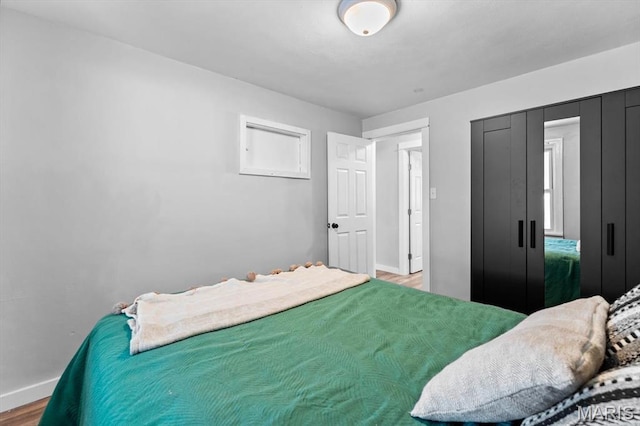 bedroom featuring baseboards and wood finished floors