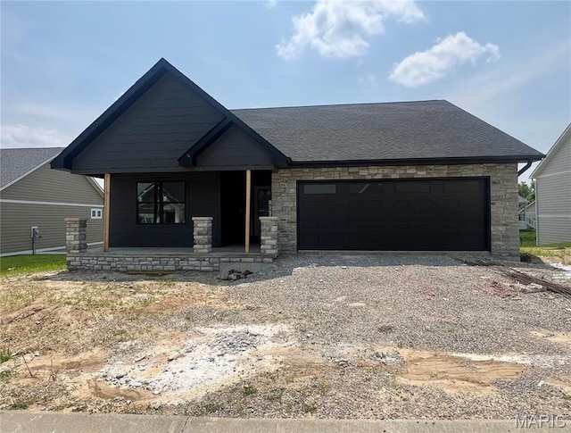 2253 Heywood Mdws, Cape Girardeau, MO 63701 - view of front of property with covered porch, stone siding, gravel driveway, an attached garage, and a shingled roof