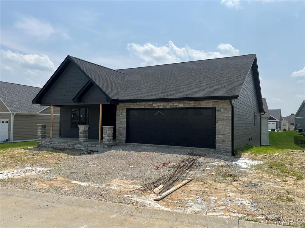 2253 Heywood Mdws, Cape Girardeau, MO 63701 - view of front facade with covered porch, an attached garage, stone siding, and dirt driveway