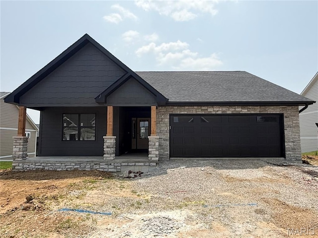 2253 Heywood Mdws, Cape Girardeau, MO 63701 - view of front facade featuring a porch, a garage, dirt driveway, stone siding, and a shingled roof