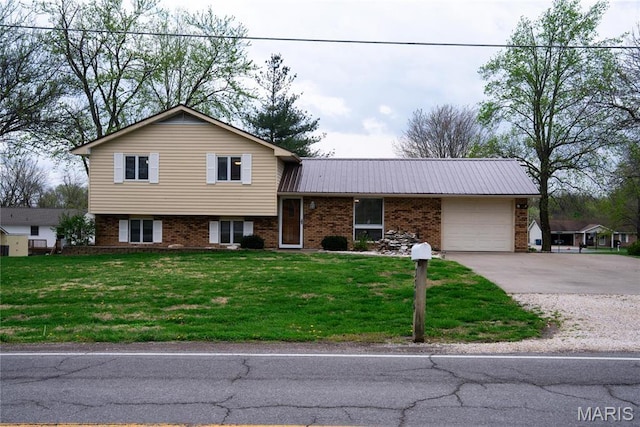 tri-level home with a garage, driveway, brick siding, a front lawn, and metal roof
