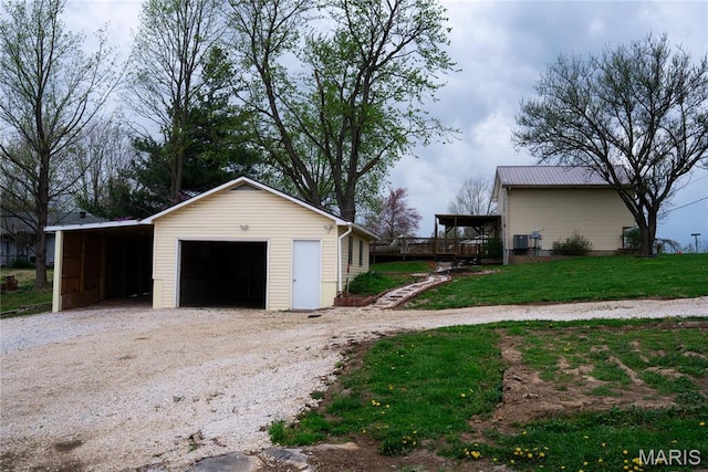 garage featuring a detached garage and gravel driveway