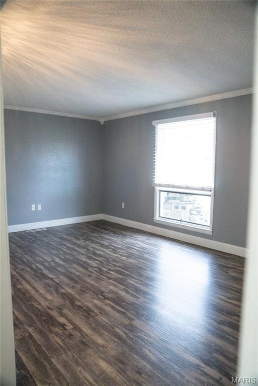 spare room with crown molding, dark wood-style floors, baseboards, and a textured ceiling