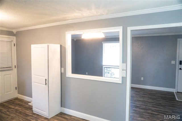 unfurnished room with dark wood finished floors, ornamental molding, and baseboards