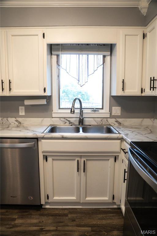 kitchen featuring dishwasher, a sink, white cabinets, and crown molding