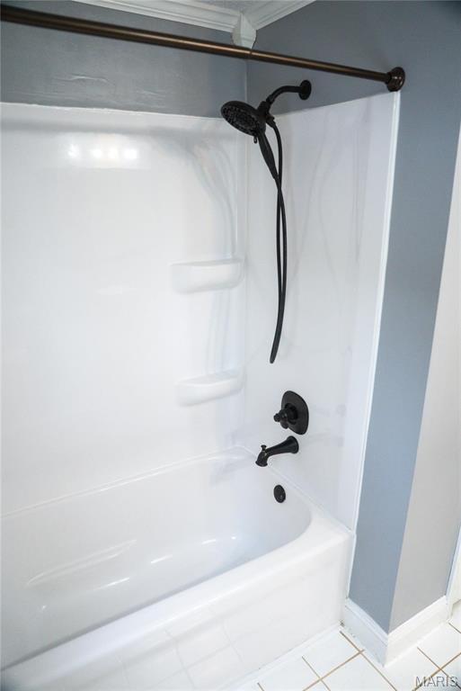 bathroom with tile patterned floors and shower / washtub combination