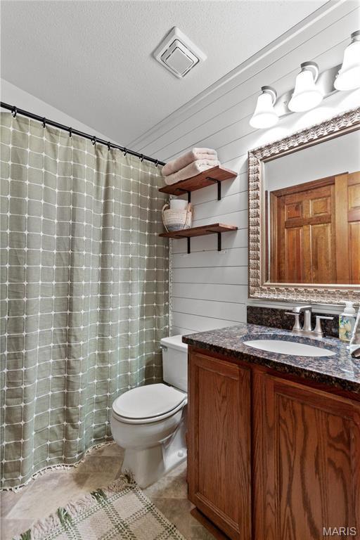 1009 Hemingway Ln Unit H, Weldon Spring, MO 63304 - bathroom with toilet, vanity, lofted ceiling, a textured ceiling, and tile patterned floors