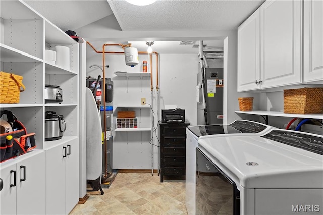 1009 Hemingway Ln Unit H, Weldon Spring, MO 63304 - washroom featuring washer and clothes dryer, water heater, heating unit, stone finish flooring, and cabinet space