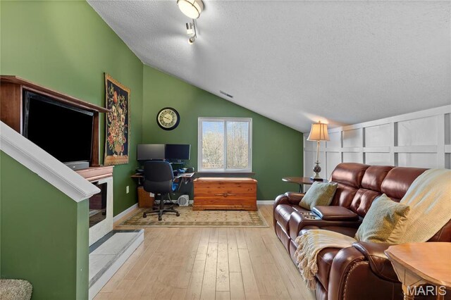 1009 Hemingway Ln Unit H, Weldon Spring, MO 63304 - living area featuring a textured ceiling, lofted ceiling, wood-type flooring, an office area, and baseboards