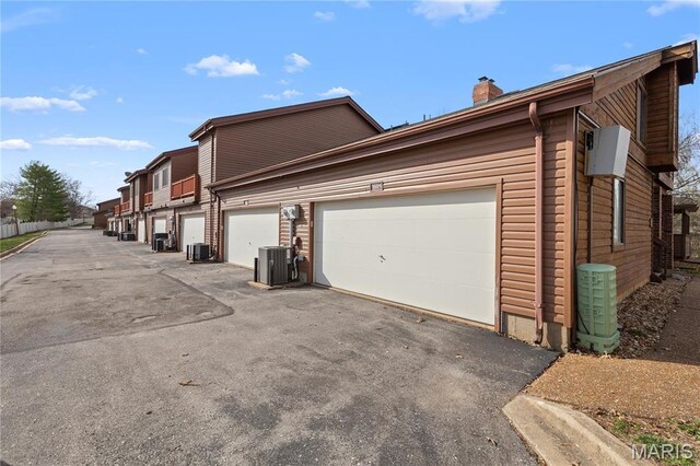 1009 Hemingway Ln Unit H, Weldon Spring, MO 63304 - view of property exterior featuring a chimney, central AC, and driveway