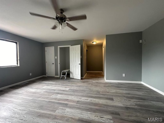 unfurnished bedroom featuring baseboards, wood finished floors, and ceiling fan