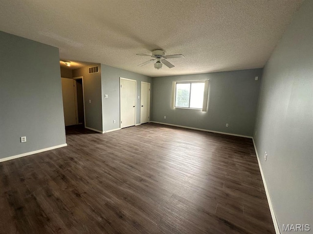 unfurnished room with ceiling fan, baseboards, dark wood-style flooring, and a textured ceiling