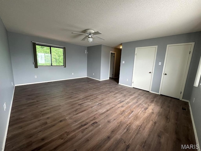 spare room with dark wood-style floors, ceiling fan, a textured ceiling, and baseboards