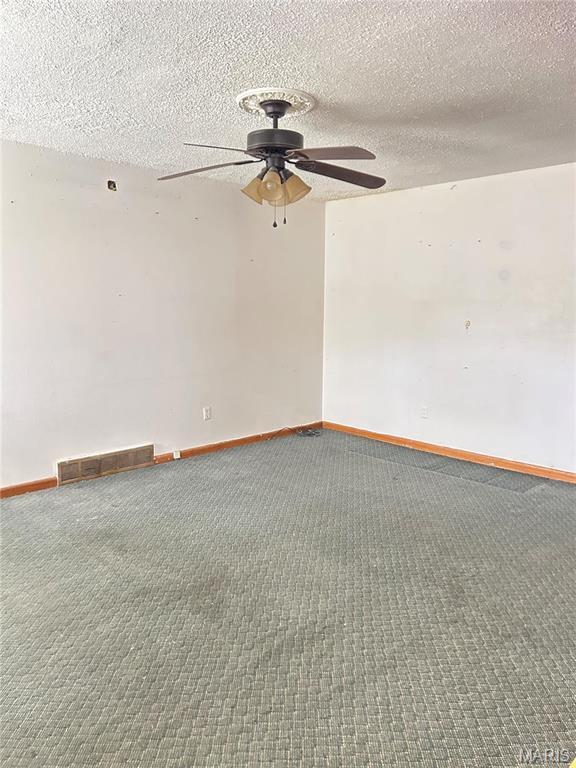 3757 Itaska St, Saint Louis, MO 63116 - carpeted spare room featuring a ceiling fan, baseboards, and a textured ceiling