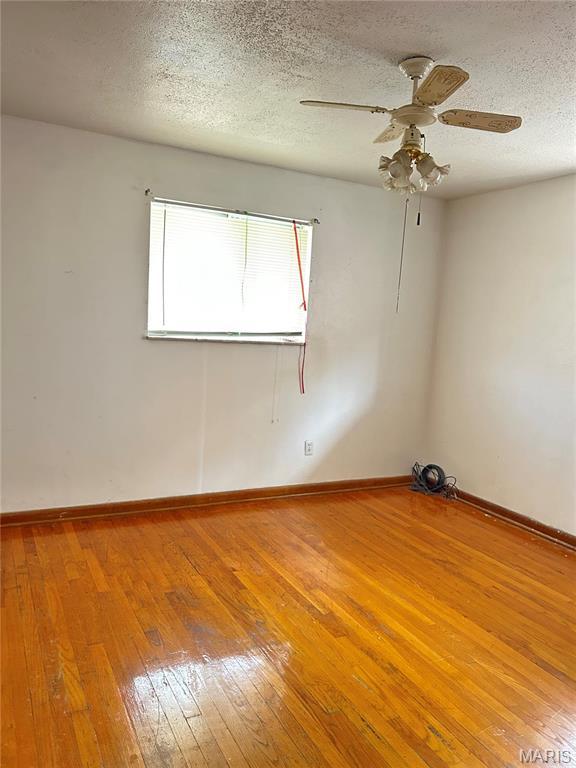 3757 Itaska St, Saint Louis, MO 63116 - unfurnished room featuring hardwood / wood-style flooring, ceiling fan, a textured ceiling, and baseboards